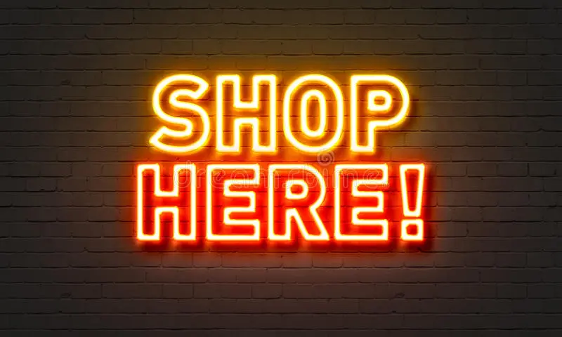 Shop here neon sign on brick wall background